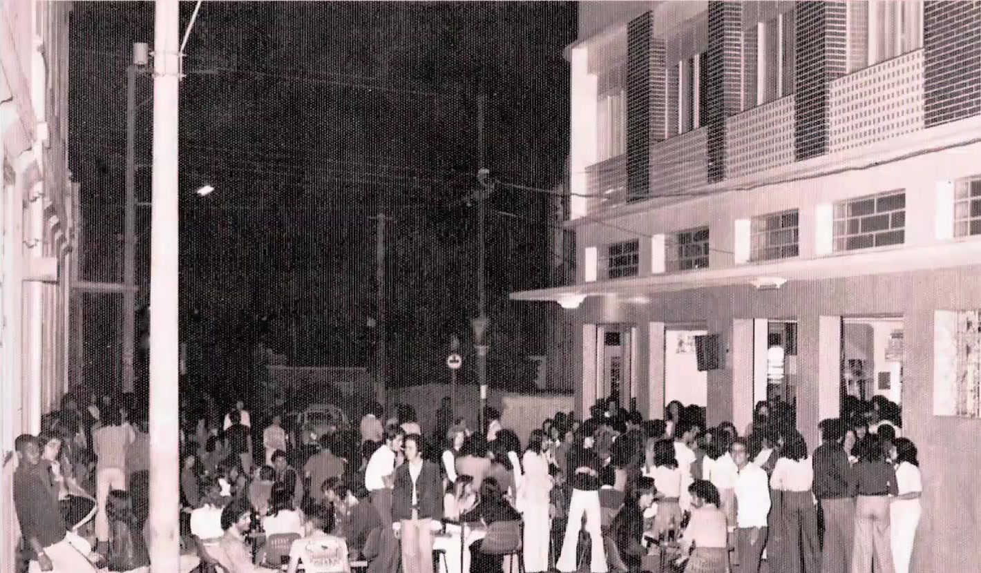 O Bar do Ponto lotado numa noite em Lavras: mesas na calçada e gente em pé até o meio da rua