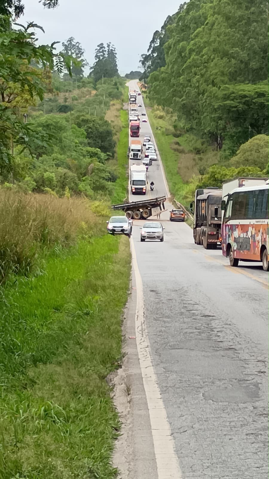 Fila de veículos na BR-265 com a carroceria da carreta atravessada na pista; só carros pequenos passavam pelo trecho · Foto: Reprodução/WhatsApp