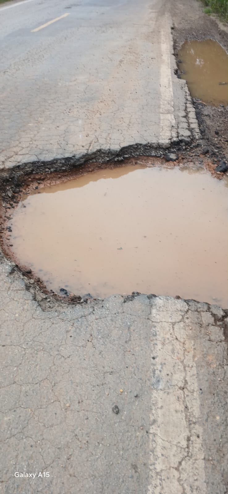 Outra cratera com água no limite entre a pista e o acostamento. Foto: enviada por ouvinte à Rádio Cultura