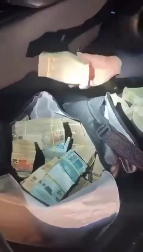 Parte do dinheiro encontrado na mala, no porta-malas do HB20. Imagem: Divulgação/PRF